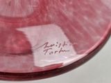 a pink plate with writing on it on a table
