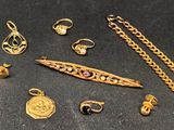 some gold jewelry is laying on a black surface