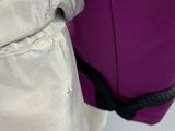 un gros plan d'une personne tenant un sac violet et noir