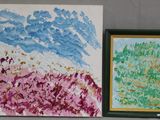 deux tableaux accrochés au mur au-dessus d'un vase et d'un autre vase