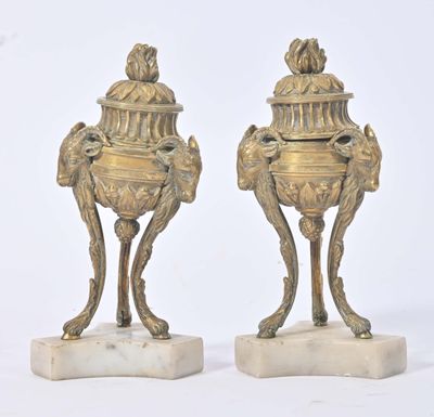 paire de vases anciens en laiton posés sur des socles en marbre et surmontés d'un oiseau