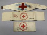 three medical bracelets with a red cross on them on a table