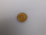a close up of a gold coin on a white surface