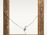 an old wooden frame with a rope hanging from it ' s side