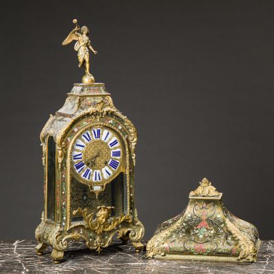 an antique clock with a statue on top of it next to a small clock
