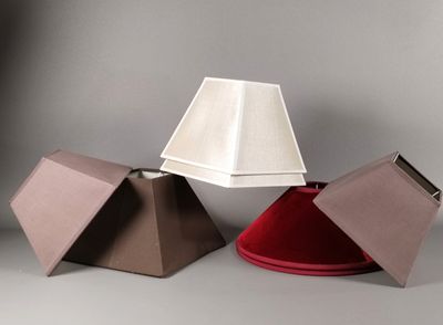 trois lampes de couleurs différentes posées les unes à côté des autres sur une surface grise