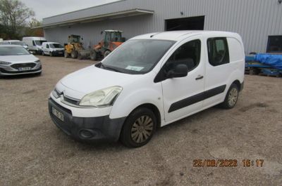 la petite camionnette blanche est garée devant un bâtiment