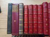 several old books are lined up on a shelf in a library