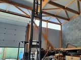 a forklift in a warehouse with a lot of junk