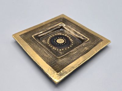 plaque en laiton ornée d'un motif carré noir et or