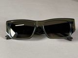 a pair of black sunglasses on a white surface