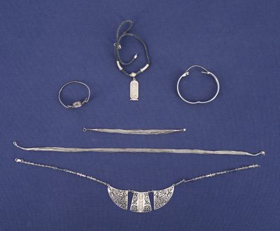de nombreux bijoux en argent sur un fond bleu