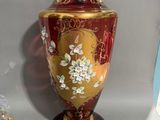 un vase rouge et doré posé sur une table