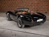 a black sports car parked in front of a brick wall