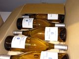several bottles of wine are in a cardboard box on a table