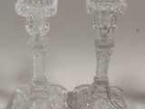 two glass candlesticks sitting on a table