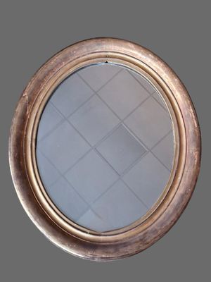 a close up of a round mirror on a gray wall