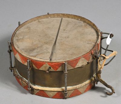 un vieux tambour orné d'un motif rouge et blanc sur le côté
