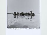 black and white photograph of a group of people floating in a body of water