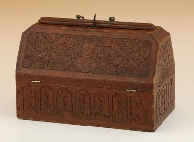 une vieille boîte en bois sculptée posée sur une surface blanche