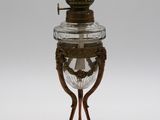 une lampe à huile ancienne en laiton et en verre sur fond blanc
