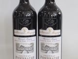 two bottles of wine sitting next to each other on a table