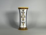 un vase blanc orné d'un motif bleu et jaune