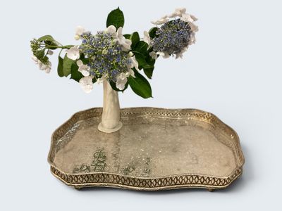 un vase avec des fleurs sur un plateau sur une table