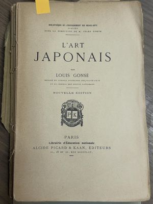 an old book sitting on top of a wooden table next to a cup of coffee