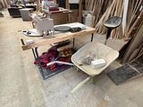 a wheelbarrow in the middle of a room full of wood planks