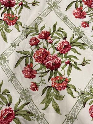 a white table cloth with red and green flowers on it