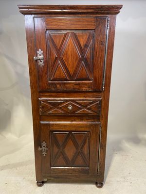 une vieille armoire en bois avec une porte et un tiroir en dessous