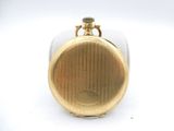 a small gold pocket watch on a white surface