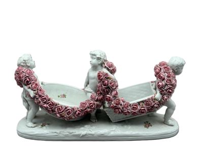 une figurine représentant deux personnes dans un bateau, décorée de roses