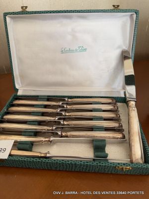 silverware in a green case sitting on a table with a price tag