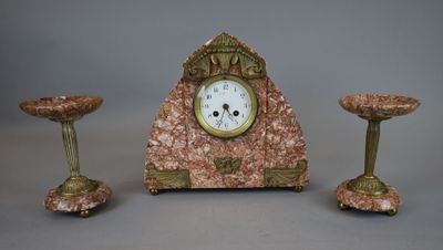une horloge posée sur une table à côté de trois bougies
