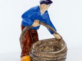 une figurine représentant un homme avec un seau d'eau
