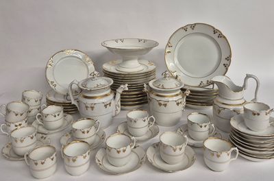 beaucoup d'assiettes, de tasses et de soucoupes blanches et dorées