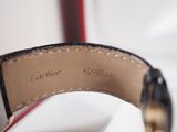 the strap of a watch is black and gold with a gold buckle