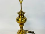an antique brass table lamp with a cord attached to it