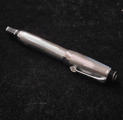 un stylo argenté posé sur une surface noire