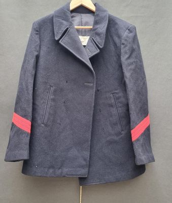 Le manteau est suspendu à un cintre accroché au mur.