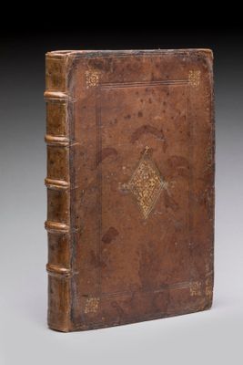 un vieux livre à la couverture brune posé sur une table