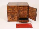 a small wooden cabinet with two drawers and a red tray