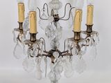 une image représentant un lustre à trois branches orné de pendentifs en cristal