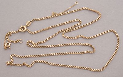 a close up of a gold chain on a gray surface