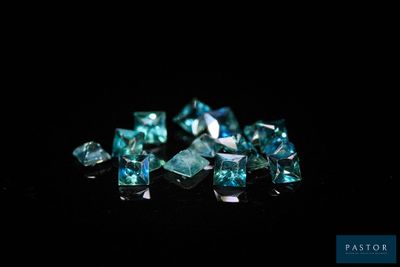 un gros plan sur un bouquet de diamants bleus posés sur une surface noire