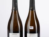 deux bouteilles de vin posées l'une à côté de l'autre sur une table