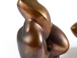 une sculpture en bronze représentant une grenouille assise sur une feuille
