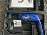 un outil bleu et noir dans un étui posé par terre
